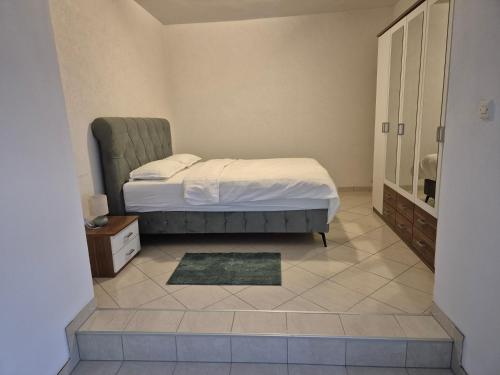 a bedroom with a bed and a tiled floor at Apartman Pecara in Široki Brijeg