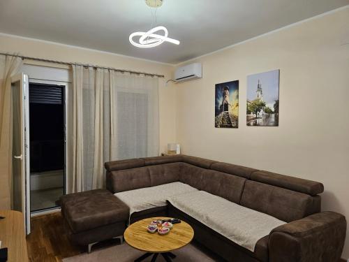 a living room with a brown couch and a table at Elena Residence 15min from Belgrade in Pančevo