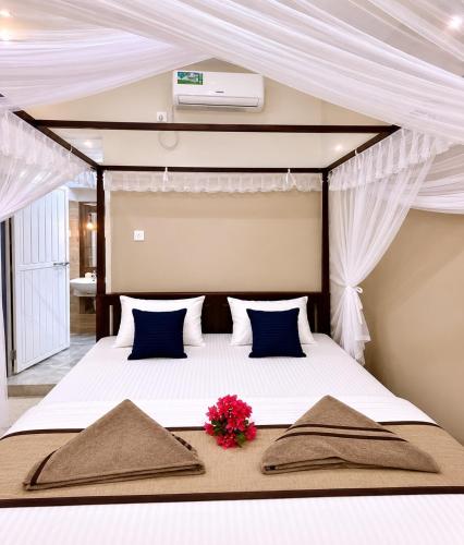 a bedroom with a bed with a flower on it at Friendly Waves Resort Arugambay in Pottuvil