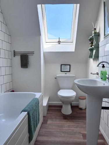a bathroom with a sink toilet and a window at Daisy Cottage with seasonal Swimming Pool in Le Mesnil-Gilbert