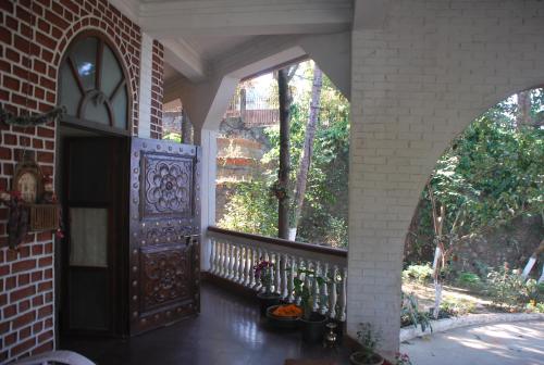 a porch with an open door and a balcony at Hilltop Lodge in Guwahati