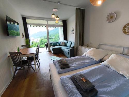 a bedroom with two beds and a table and a couch at MOOKI Sky by Lake in Villach
