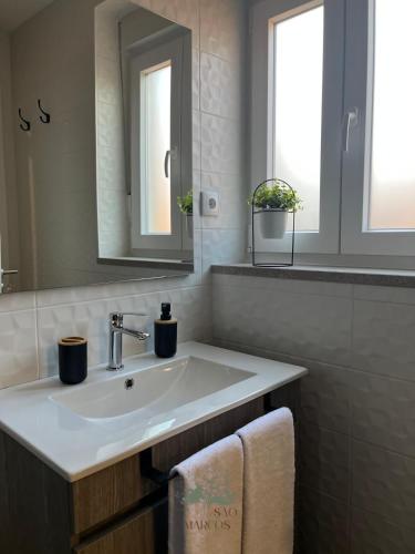 a bathroom with a sink and a mirror at Quintal de São Marcos in Castelo Branco