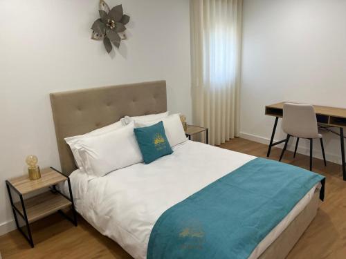 a bedroom with a bed with a table and a desk at Quintal de São Marcos in Castelo Branco