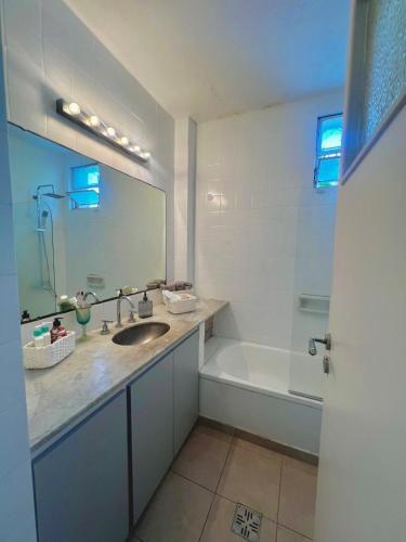 a bathroom with a sink and a tub and a mirror at Mi petit Paraiso in San Isidro