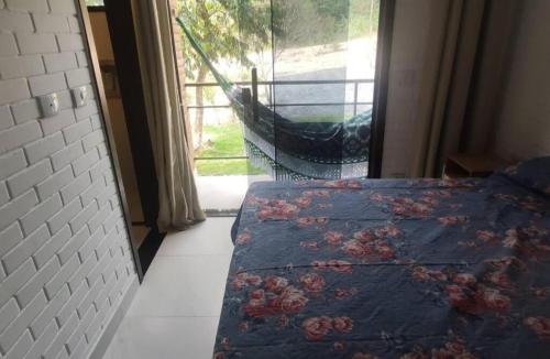a bedroom with a bed and a window with a view at Nossa Casa em Lençóis - Bahia in Lençóis