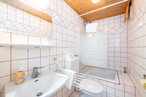 a white bathroom with a sink and a toilet at Kesslerhütte Planai - by myNests in Schladming