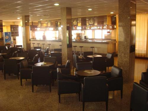 a restaurant with tables and chairs and a bar at Hotel Univers in Roses