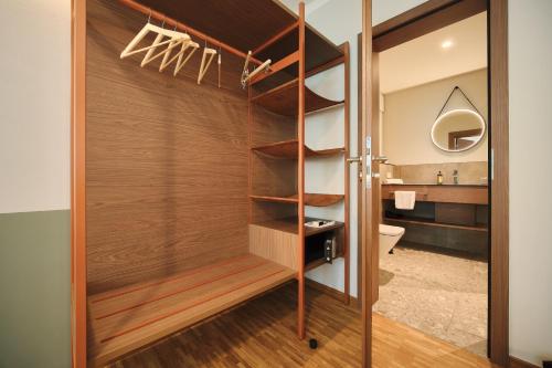 a bathroom with a wooden door with a toilet and a sink at Hotel & Brauereigasthof Drei Kronen in Memmelsdorf