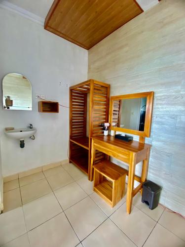 a bathroom with a wooden desk and a sink at De La Sierra in Munduk