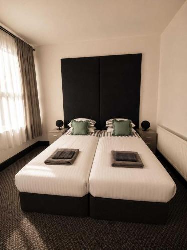 a bedroom with a large bed with two pillows at GuestReady - The Hangman in Liverpool