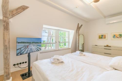 a white bedroom with a bed and a window at Strandvilla Lilli in Timmendorfer Strand