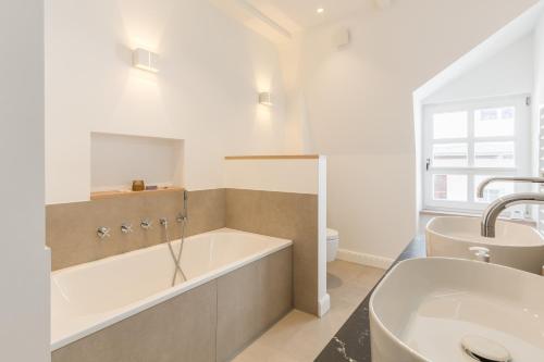 a bathroom with a tub and a sink at Strandvilla Lilli in Timmendorfer Strand