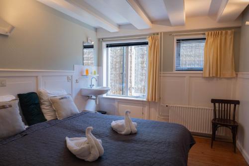 a bedroom with two swans on a bed at 't Lytse Knipke in Lemmer