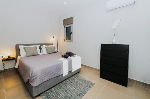 a bedroom with a bed and a black dresser at Breathtaking view guesthouse2 in Psalidi