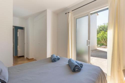 a bedroom with a bed with blue towels on it at Calma Menorca in Arenal d'en Castell