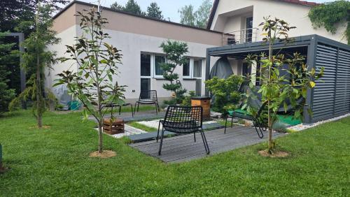 a backyard with two benches and trees in the grass at Dom na Pięknej Ustroń in Ustroń