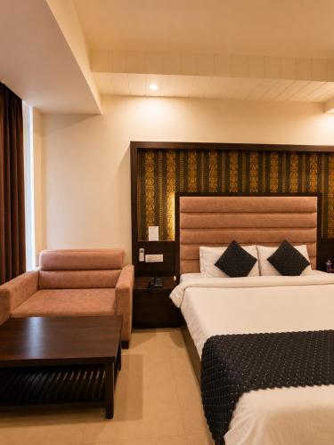 a hotel room with two beds and a couch at Hotel Krishna in Katra