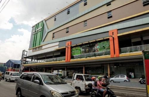 a group of people riding a motorcycle in front of a building at Nice Hotel Mac Arthur in Manila
