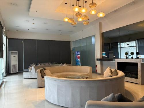 a large living room with couches and a fireplace at Nice Hotel Mac Arthur in Manila