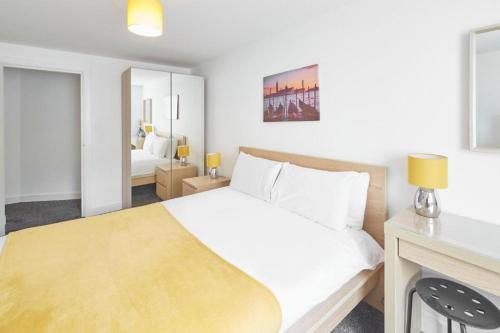 a bedroom with a white bed and a mirror at Skinningrove Beach Apartment 5 in Skinningrove