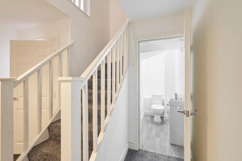a white bathroom with a toilet and a staircase at Skinningrove Beach Apartment 5 in Skinningrove
