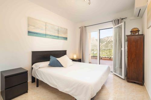 a bedroom with a bed and a large window at Can Cega in Bunyola