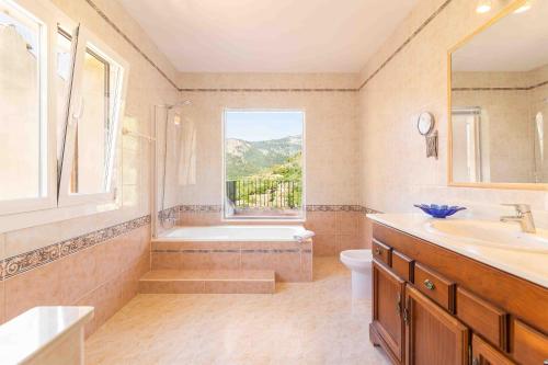 a bathroom with a tub and a toilet and a window at Can Cega in Bunyola