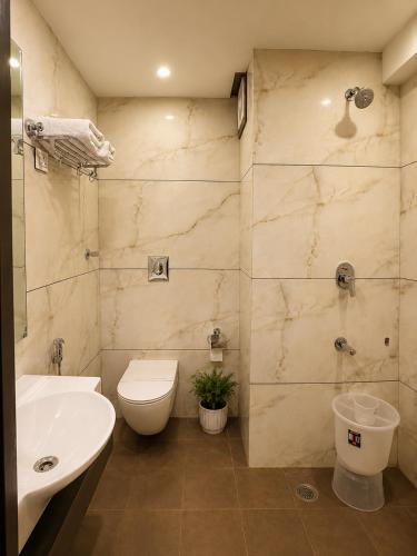 a bathroom with a sink and a toilet and a sink at Hotel Krishna in Katra