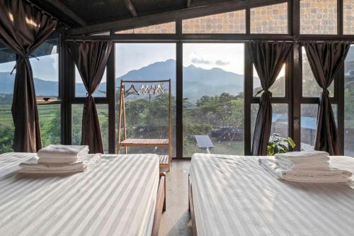 two beds in a room with a large window at Greenfield Ba Vì - Nắng Villa in Yên Bài