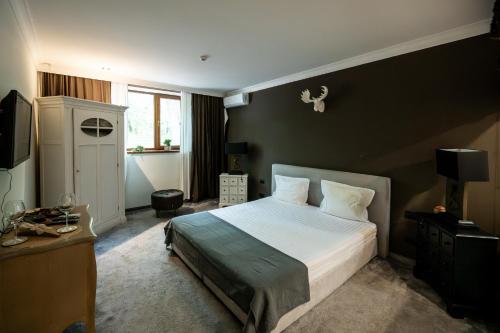 a bedroom with a large bed and a television at Villa VICTORIA Loven Park Boutique Rooms Sofia in Sofia