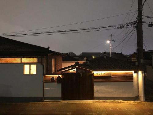 a house with a wooden fence in front of it at night at Gyeongju eupseong dokchae hanok in Gyeongju