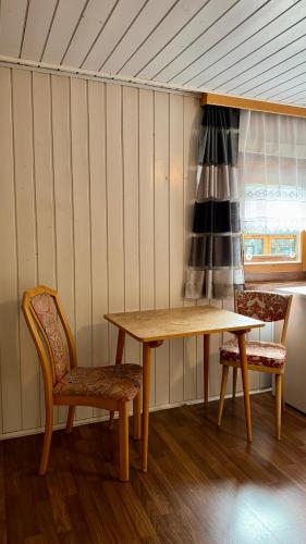 a wooden table and two chairs in a room at SKILL Mountain Lodge - Ski und Bike Hostel im Sommer mit JOKER CARD in Saalbach-Hinterglemm