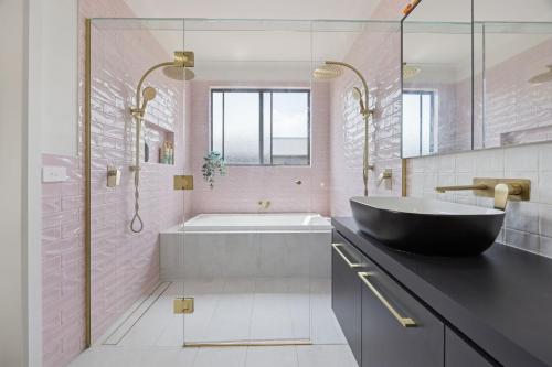 a bathroom with a black tub and a sink at Snowy Lake Haven in Jindabyne