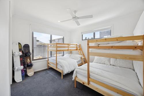a bedroom with two bunk beds and snowboards at Snowy Lake Haven in Jindabyne