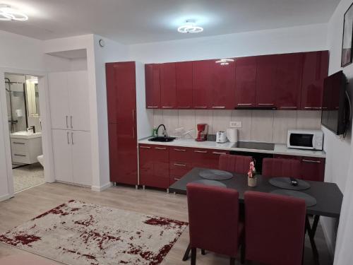 a kitchen with red cabinets and a table with chairs at Karp Studio in Sinaia