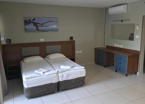 a bedroom with a bed and a flat screen tv at Regina Goren Hotel in Ashkelon