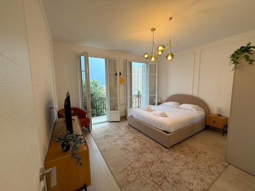 a bedroom with a bed and a large window at Frontière de Monaco - Spacieux et confortable - GM in Beausoleil