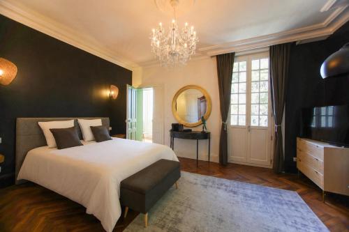 a bedroom with a bed and a mirror and a chandelier at Quatorze - manoir au coeur du parc du Château de La Garnache in La Garnache