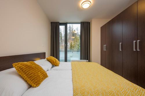 a bedroom with a large bed and a large window at Hotel Panorama in Štrbské Pleso