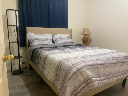 a bed in a bedroom with a blue curtain at Cozy Anchorage retreat in Anchorage