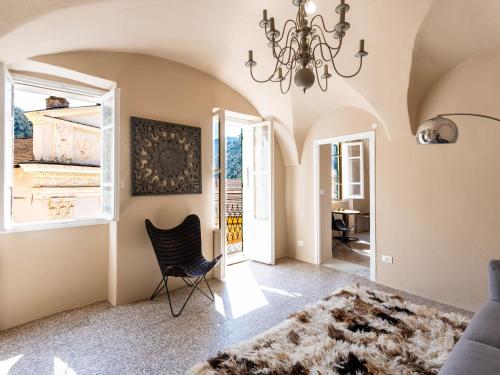 a living room with a chandelier and a chair at Apartment Nella Piazza by Interhome in Airole