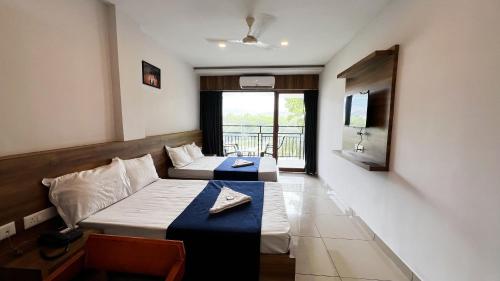 a hotel room with two beds and a couch at Peacock residency in Edavanna