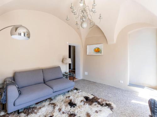 a living room with a blue couch and a chandelier at Apartment Nella Piazza by Interhome in Airole