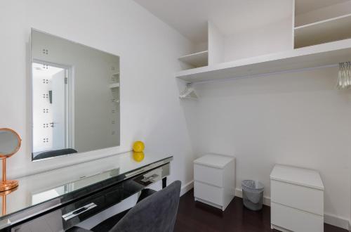 a white room with a mirror and a table at Kittiwake - Ventnor Bay with Hot Tub in Ventnor