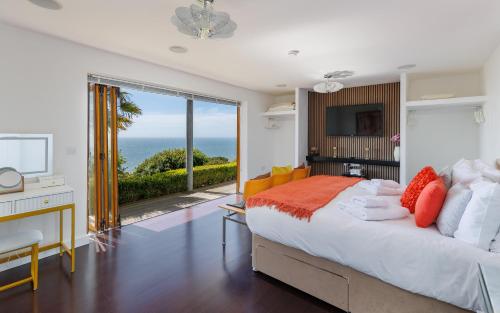 a bedroom with a bed and a desk and a television at Kittiwake - Ventnor Bay with Hot Tub in Ventnor