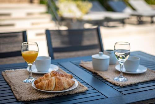 a table with two glasses of orange juice and croissants at CURICTA Design Apartments in Krk