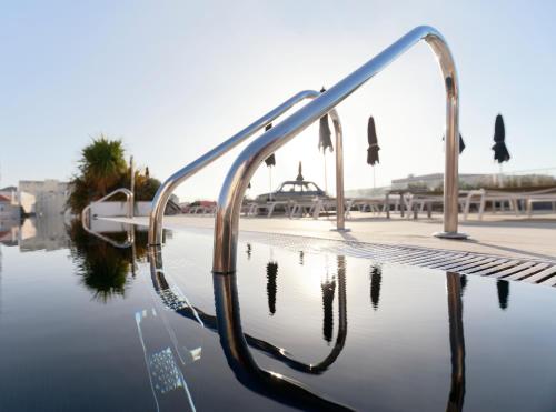 a metal hand rail next to a body of water at Hotel Inglaterra - Charme & Boutique in Estoril
