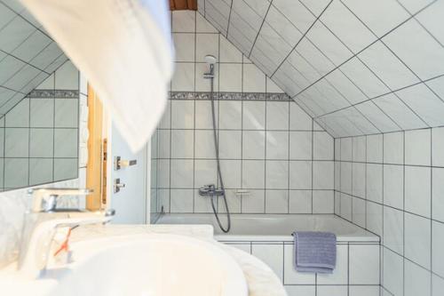 a bathroom with a shower and a sink and a tub at Ferienwohnung 12er in Sankt Gilgen