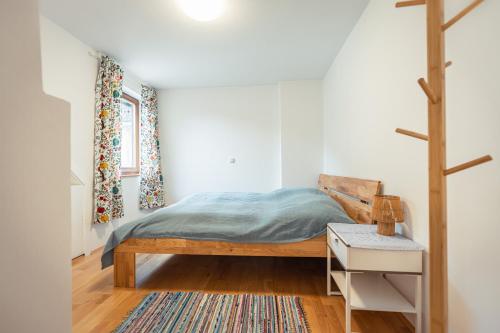 a bedroom with a bed and a night stand and a table at Ferienwohnung 12er in Sankt Gilgen